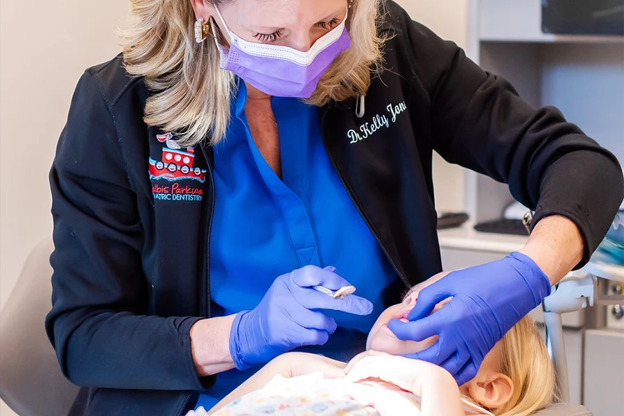Dr. Kelly Jones performing dental treatment on young child at Malbis Parkway Pediatric Dentistry