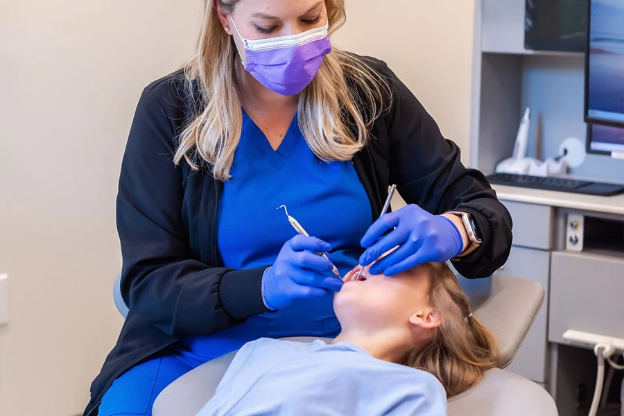 Doctor performing teeth cleaning on child patient